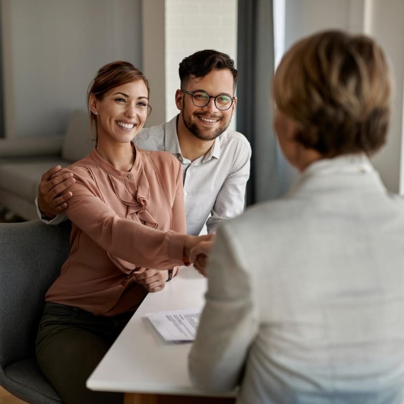 young-happy-couple-shaking-hands-with-insurance-agent-during-meeting-office young-happy-couple-shaking-hands-with-insurance-agent-during-meeting-office
